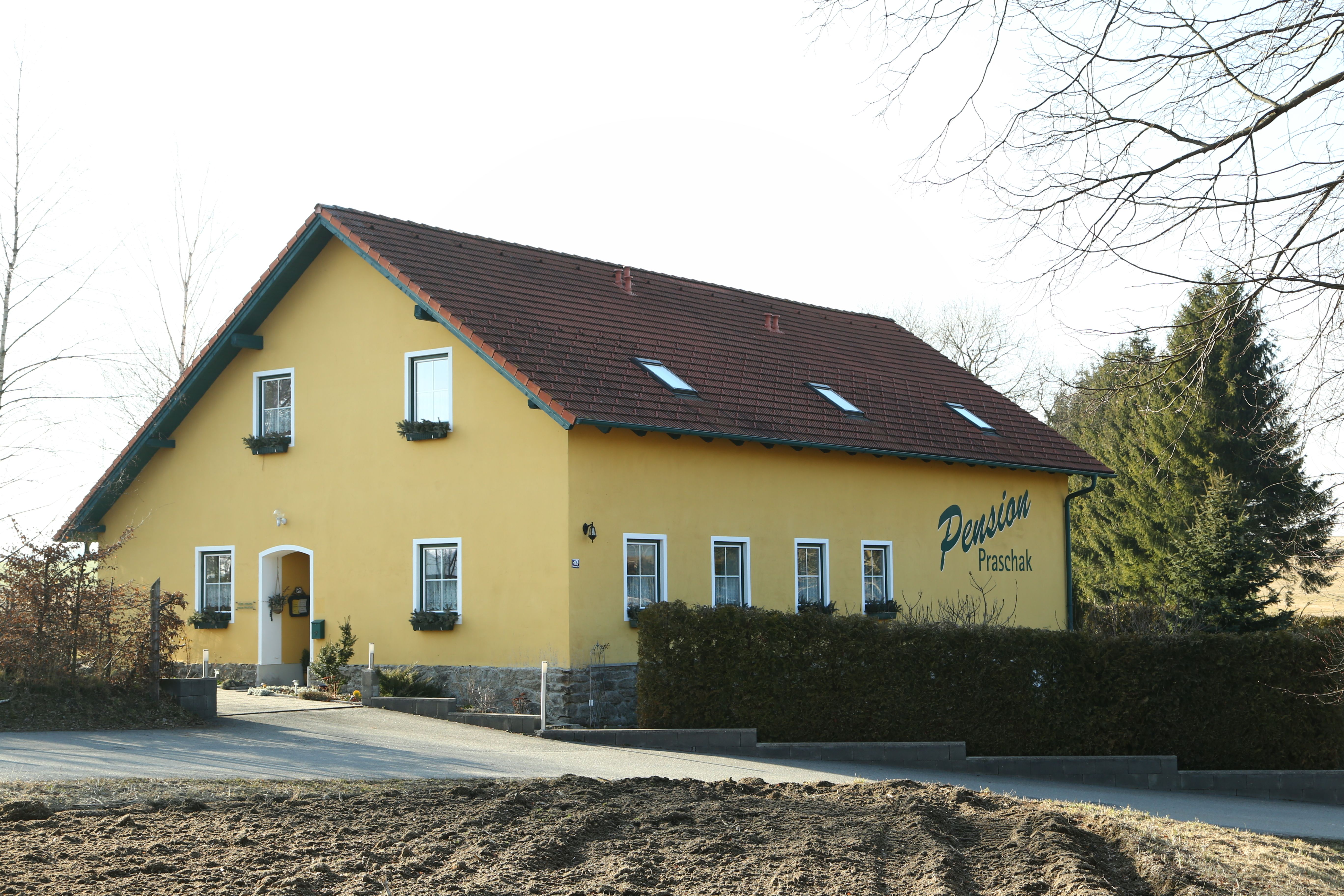 Gelbes Gebäude mit der Aufschrift 'Pension Praschak'.