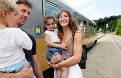 Eine fröhliche Familie genießt einen unvergesslichen Ausflug zur Waldviertelbahn. Die Kinder strahlen vor Freude, während sie die malerische Landschaft der Region erkunden. Die warme Sonne und die frische Luft schaffen eine perfekte Atmosphäre für gemeinsame Abenteuer.