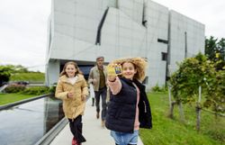 Eine fröhliche Familie genießt einen aktiven Tag im Freien, während sie mit der Niederösterreich CARD die Umgebung erkundet. Die Kinder strahlen vor Freude, während sie die Natur und die Architektur der Umgebung bewundern. Ein unvergessliches Erlebnis für Groß und Klein, das die Schönheit des Waldviertels in vollen Zügen zelebriert.