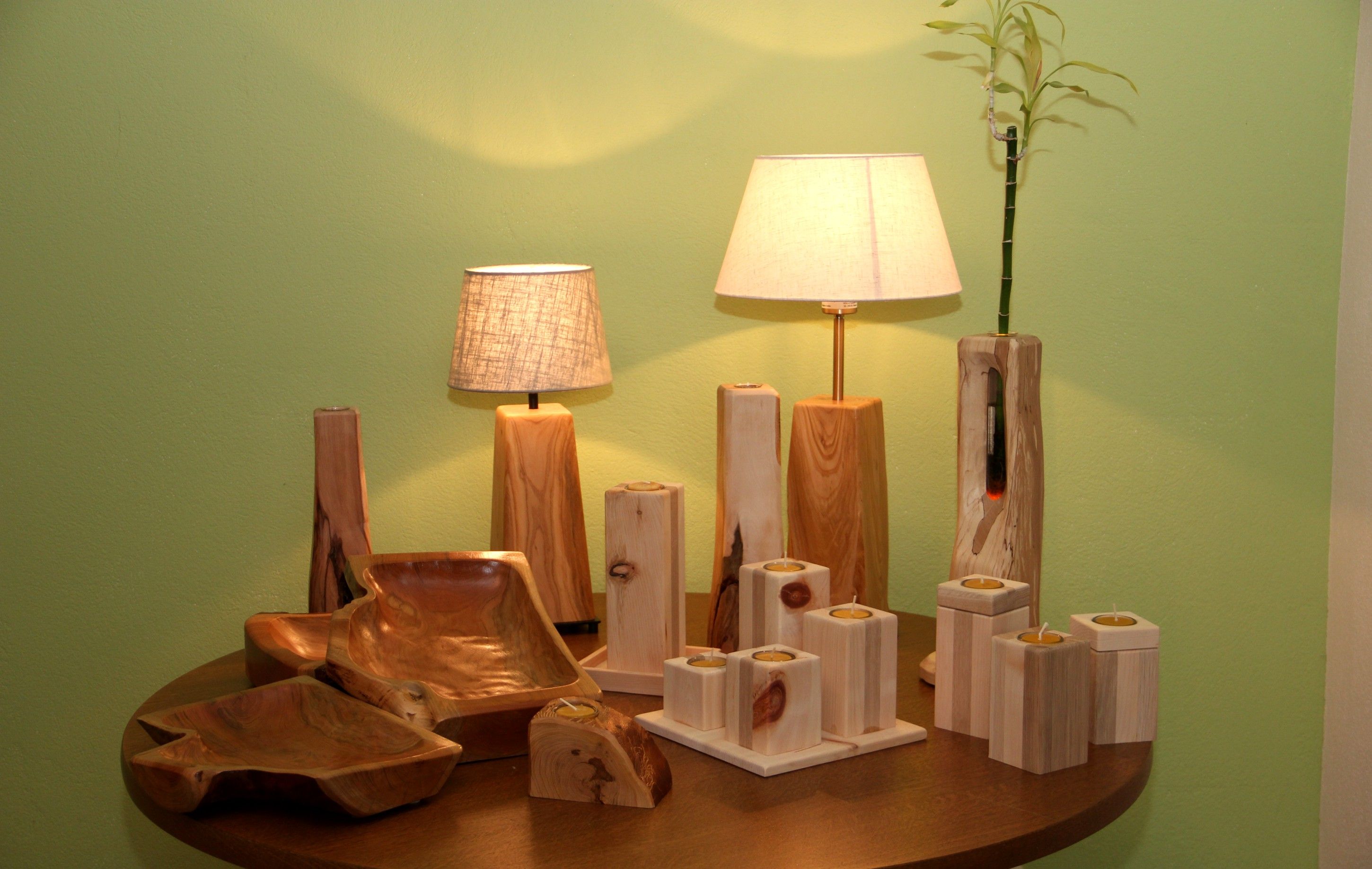 Holzhandwerk mit Lampen und Kerzenhaltern auf einem Tisch.