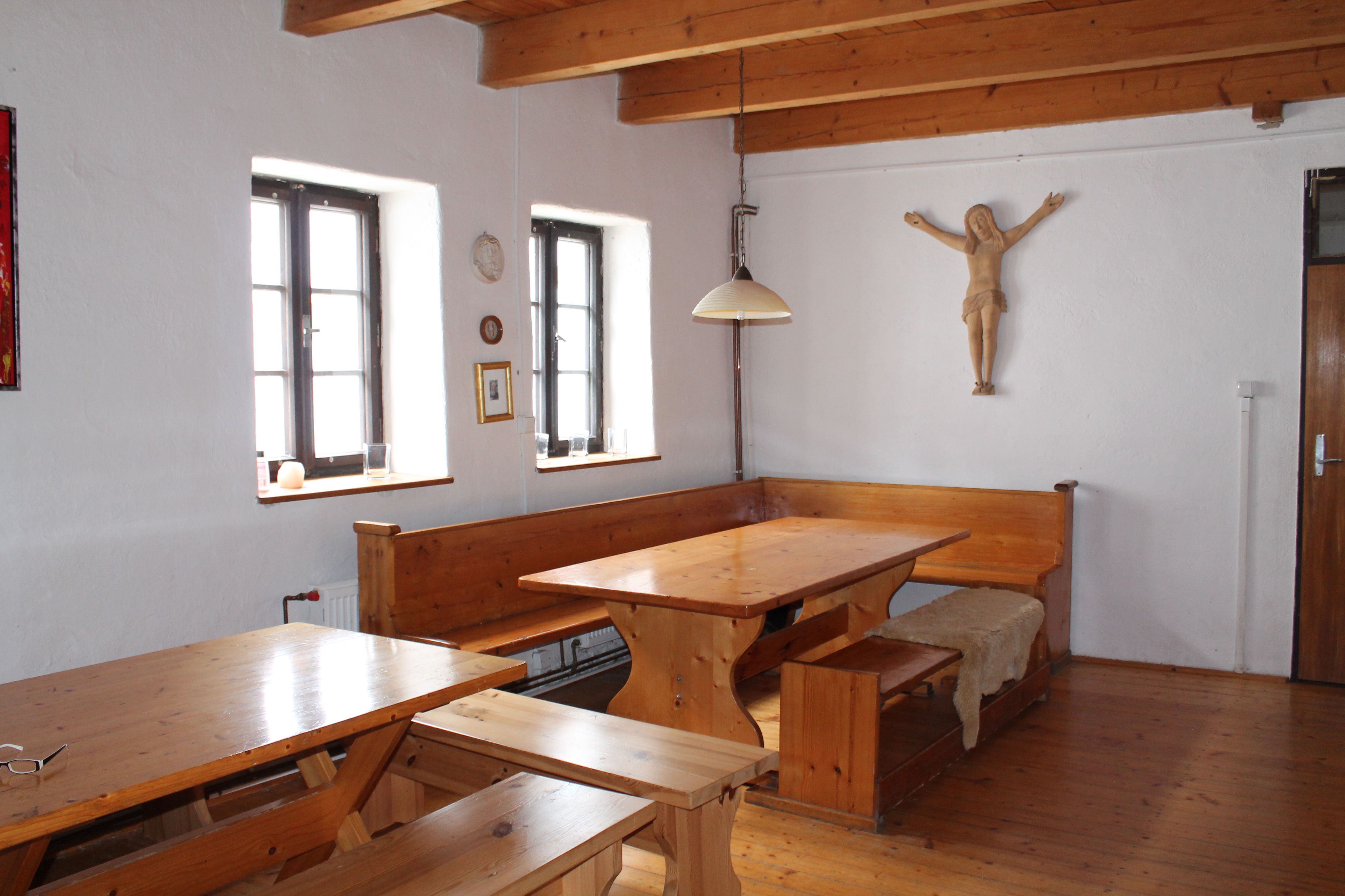 Rustikaler Raum mit Holzmöbeln, Holzbalkendecke und Wanddekoration.