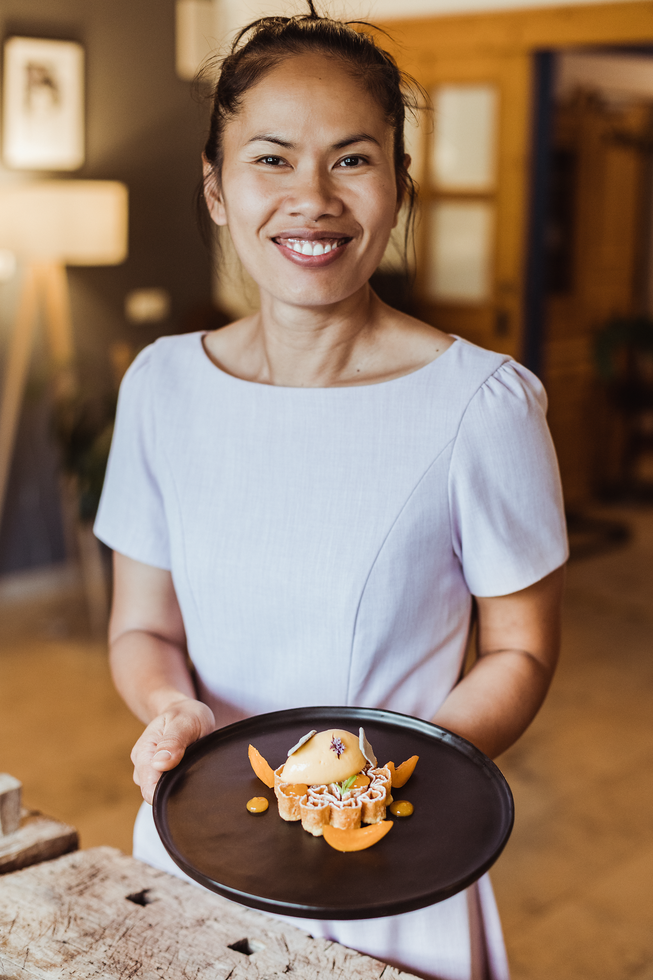 Inmitten der malerischen Landschaft des Waldviertels präsentiert die Wirtin stolz eine exquisite Weinser Waffel, die mit erfrischendem Marillensorbet und saftigen Marillen garniert ist. Der Duft von frischen Zutaten und die herzliche Gastfreundschaft laden dazu ein, die kulinarischen Köstlichkeiten in vollen Zügen zu genießen.