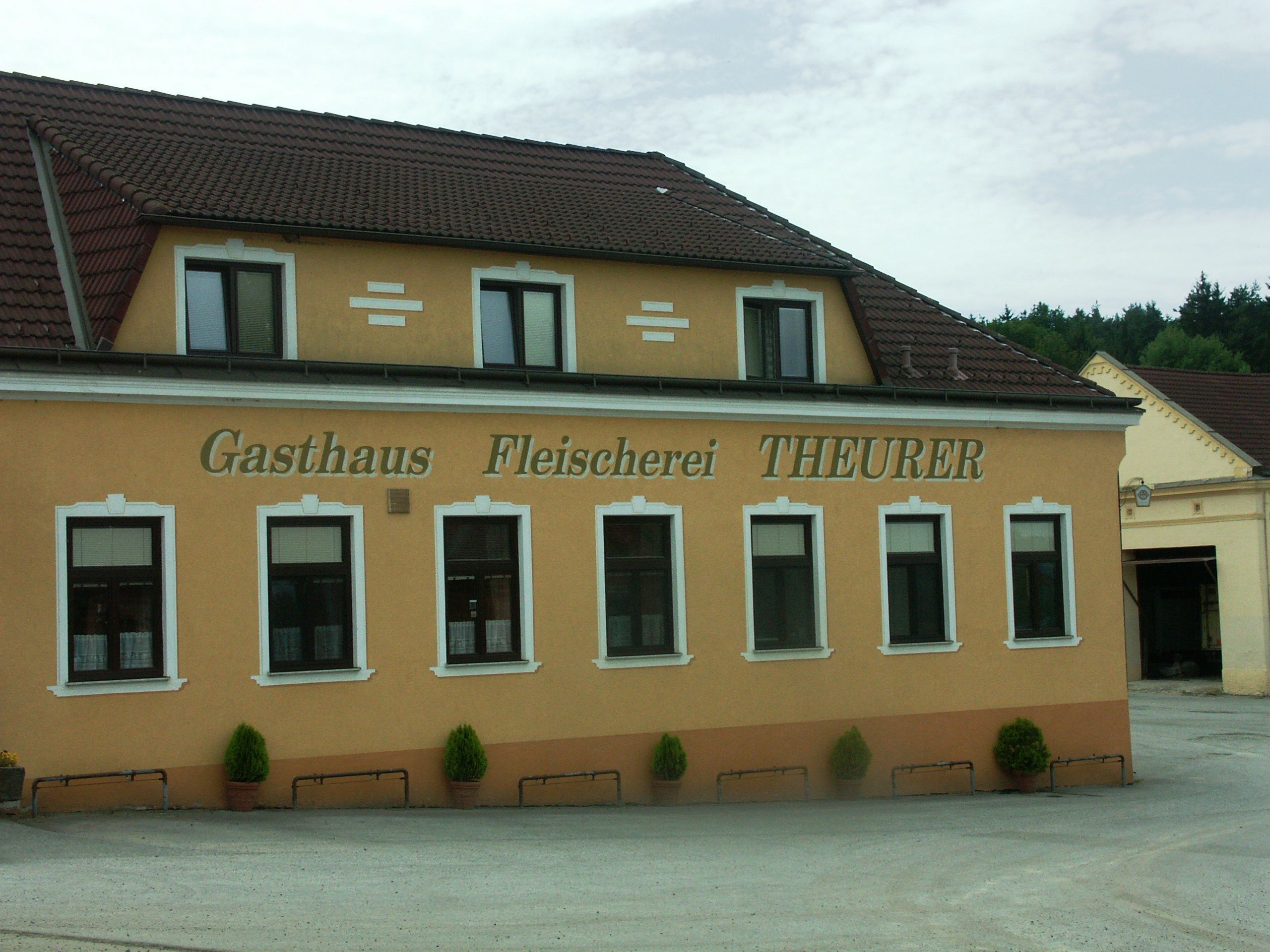 Außenansicht des Gasthauses und der Fleischerei Theurer mit gelber Fassade und braunem Dach.