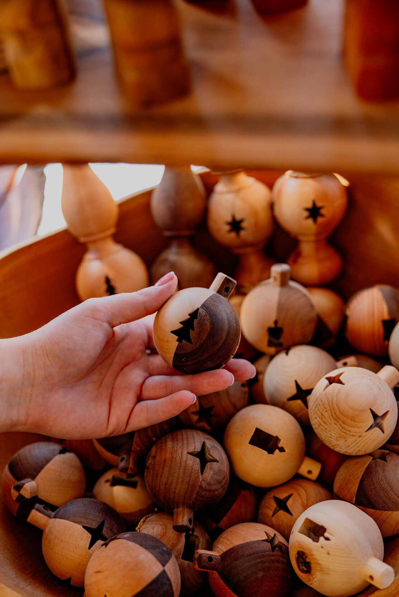 In einer warmen, einladenden Atmosphäre erstrahlen handgefertigte Holzornamente in verschiedenen natürlichen Farbtönen. Die kunstvollen Designs, die an die Tradition des Drechselns erinnern, laden dazu ein, die Schönheit des Handwerks zu entdecken und ein Stück Natur mit nach Hause zu nehmen.