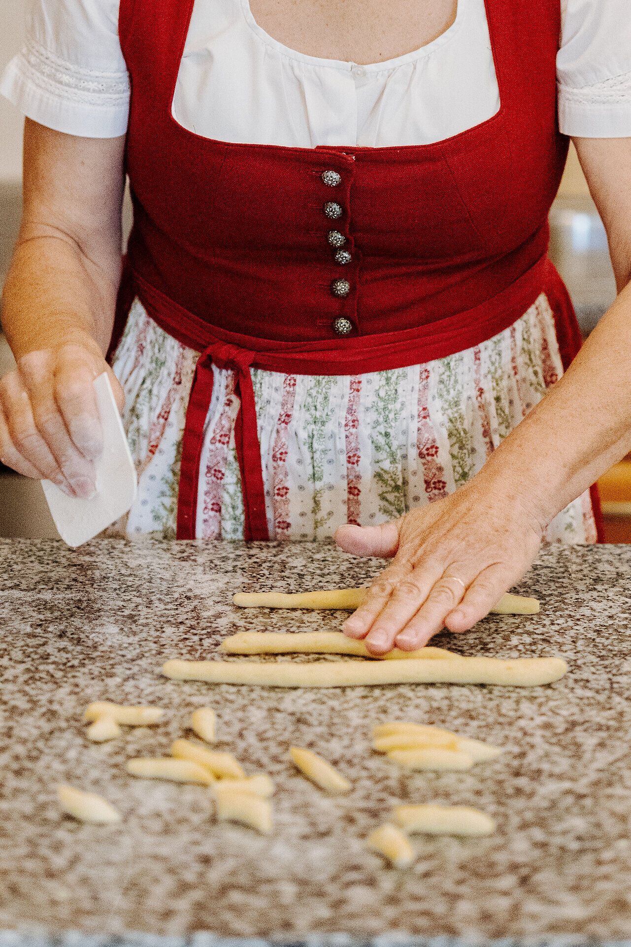 In der warmen, einladenden Atmosphäre der Mohnwirtin Rosi Neuwiesinger wird mit Hingabe und Geschick an köstlichen Mohnnudeln gearbeitet. Die Hände formen den Teig, während der Duft von frisch gebackenem Brot die Luft erfüllt und die Vorfreude auf ein unvergessliches Geschmackserlebnis weckt.