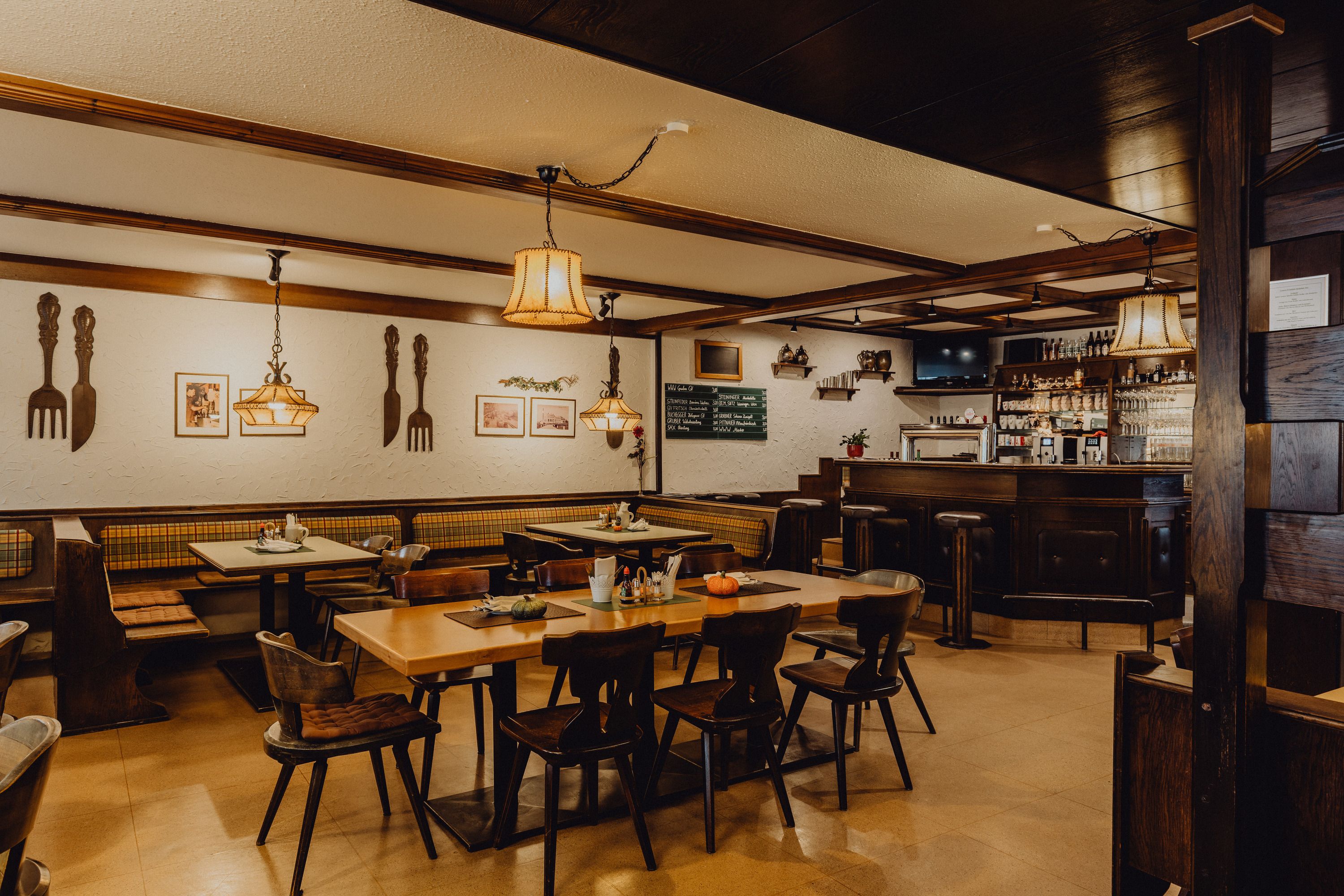 Gemütliches Wirtshaus mit Holzmöbeln, Bar und dekorativen Lampen.