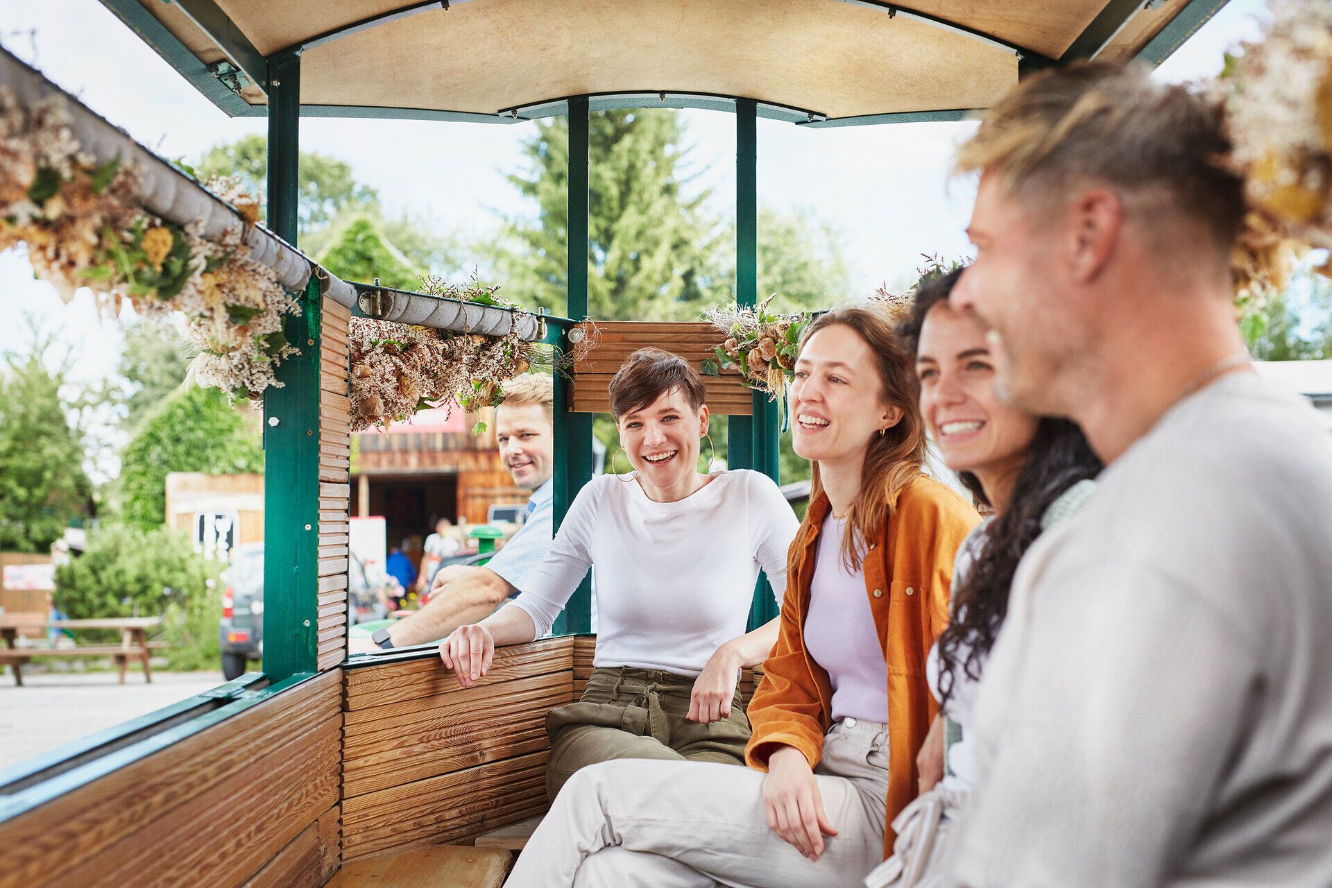 Inmitten der blühenden Mohnfelder strahlen die Gesichter der Besucher vor Freude und Entspannung. Die sanfte Brise trägt den süßen Duft der Mohnblüten, während die fröhliche Runde in der gemütlichen Atmosphäre des Mohnwirts verweilt. Hier wird der Sommer in seiner schönsten Form erlebbar.