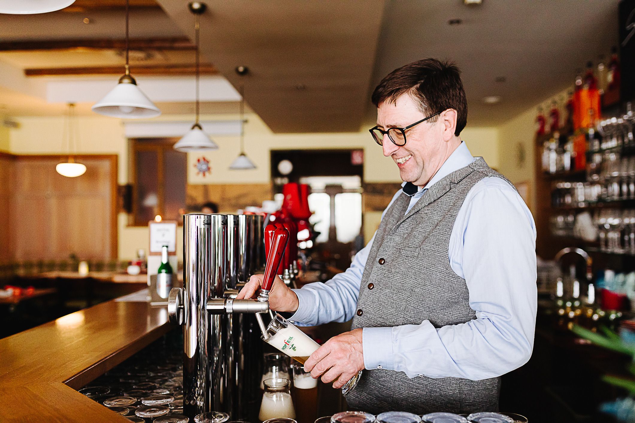 Ein Mann zapft Bier an einer Theke in einem Restaurant.