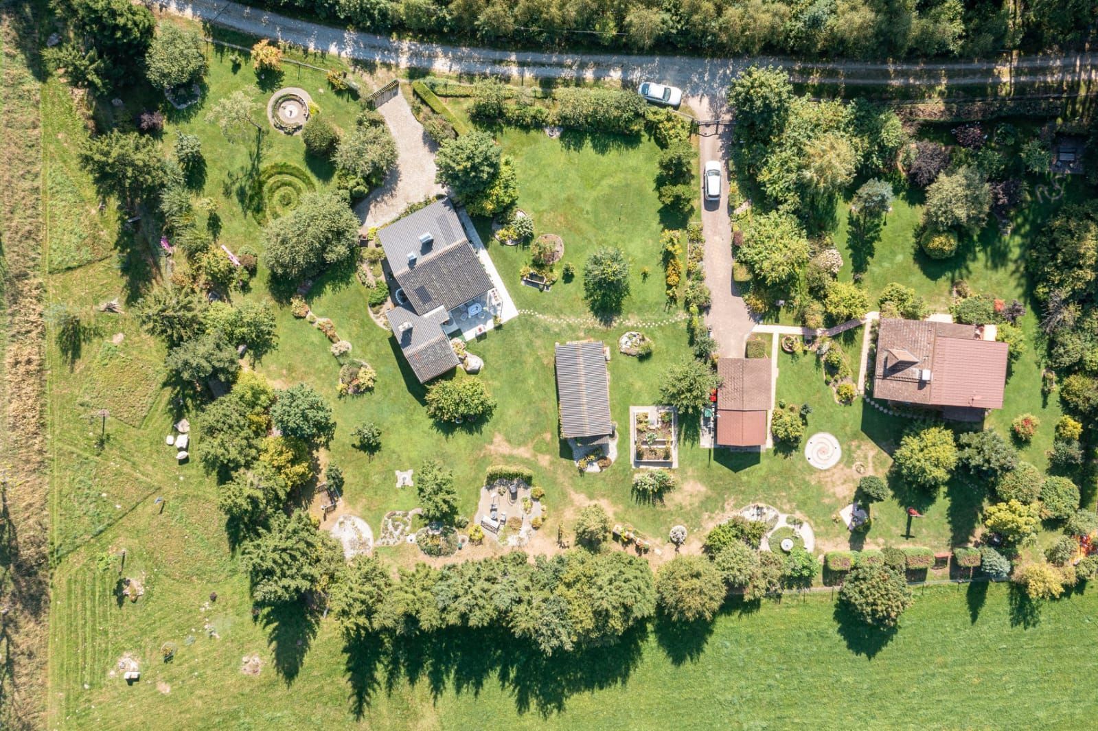 Luftaufnahme eines Gartens mit mehreren Gebäuden und Bäumen.