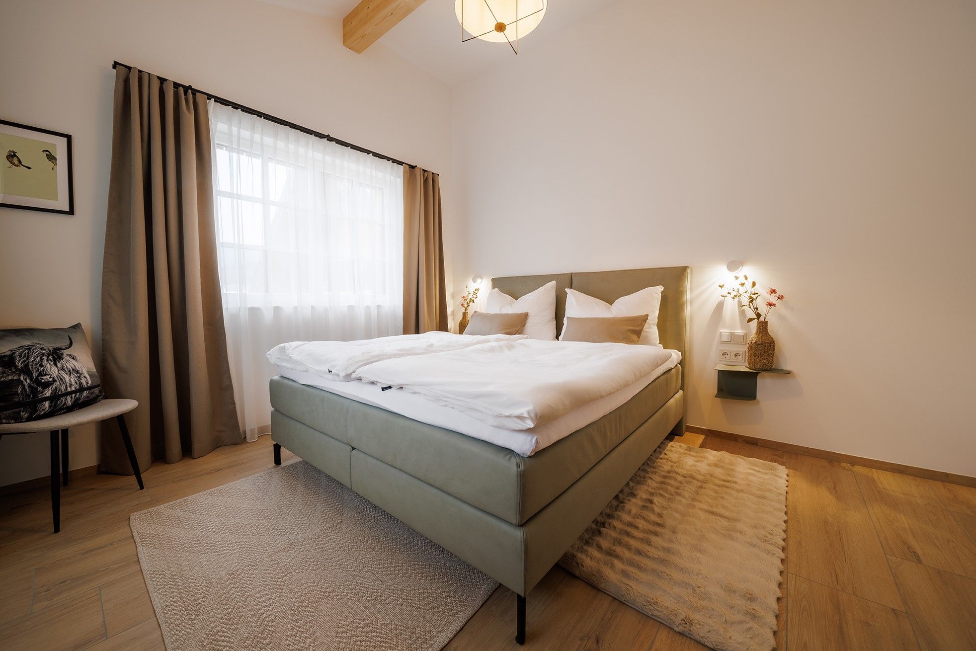 Modernes Schlafzimmer mit Doppelbett, Holzboden und großen Fenstern mit Vorhängen.