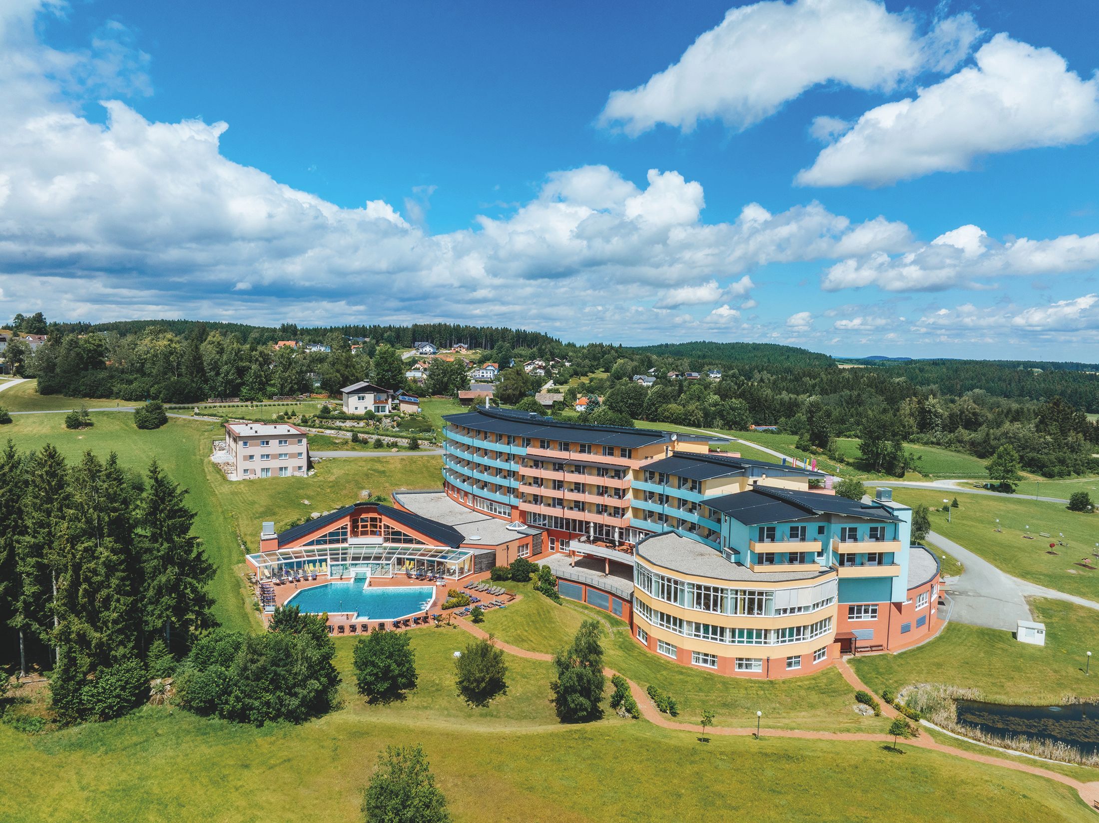 Luftaufnahme des Vivea Hotels Bad Traunstein inmitten grüner Landschaft.