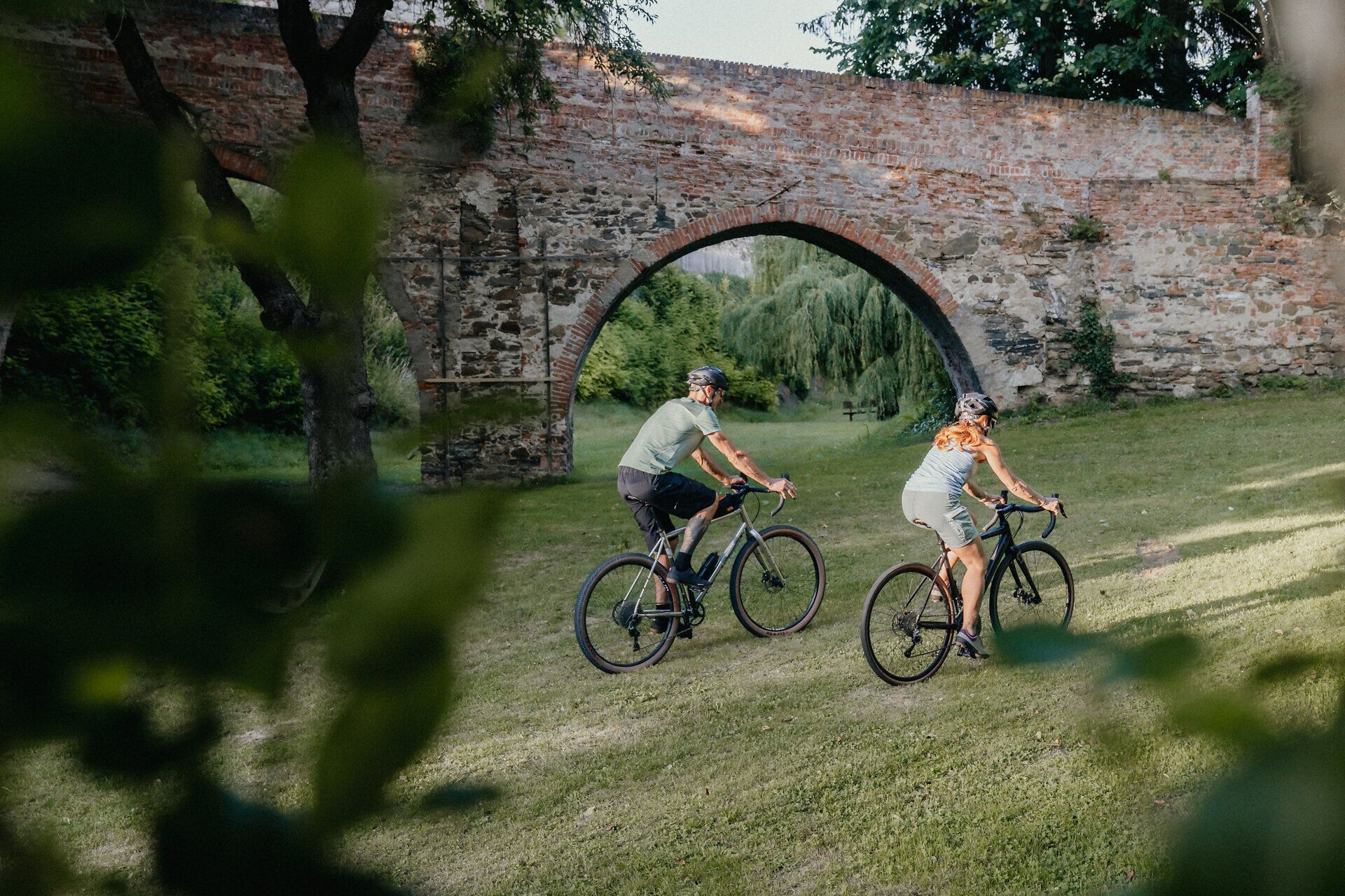 Ein Mann und eine Frau radeln entlang des Viadukts der ehemaligen Stadtmauer
