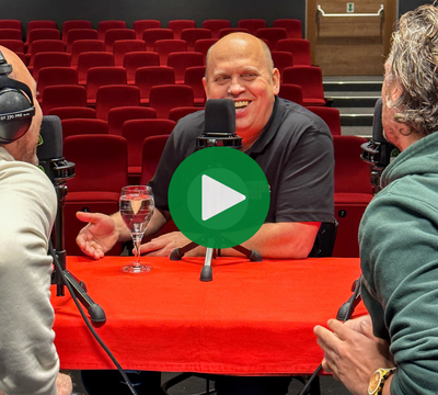 Eine Person im Fokus auf einer Bühne bei Podcastaufnahme