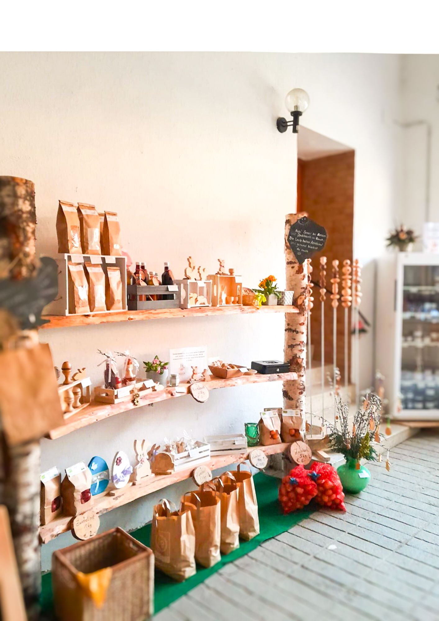 Ein Regal mit verschiedenen handgemachten Produkten und Lebensmitteln in einem kleinen Laden.