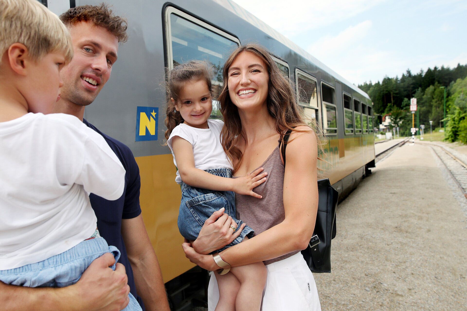 Eine fröhliche Familie genießt einen unvergesslichen Ausflug zur Waldviertelbahn. Die Kinder strahlen vor Freude, während sie die malerische Landschaft der Region erkunden. Die warme Sonne und die frische Luft schaffen eine perfekte Atmosphäre für gemeinsame Abenteuer.
