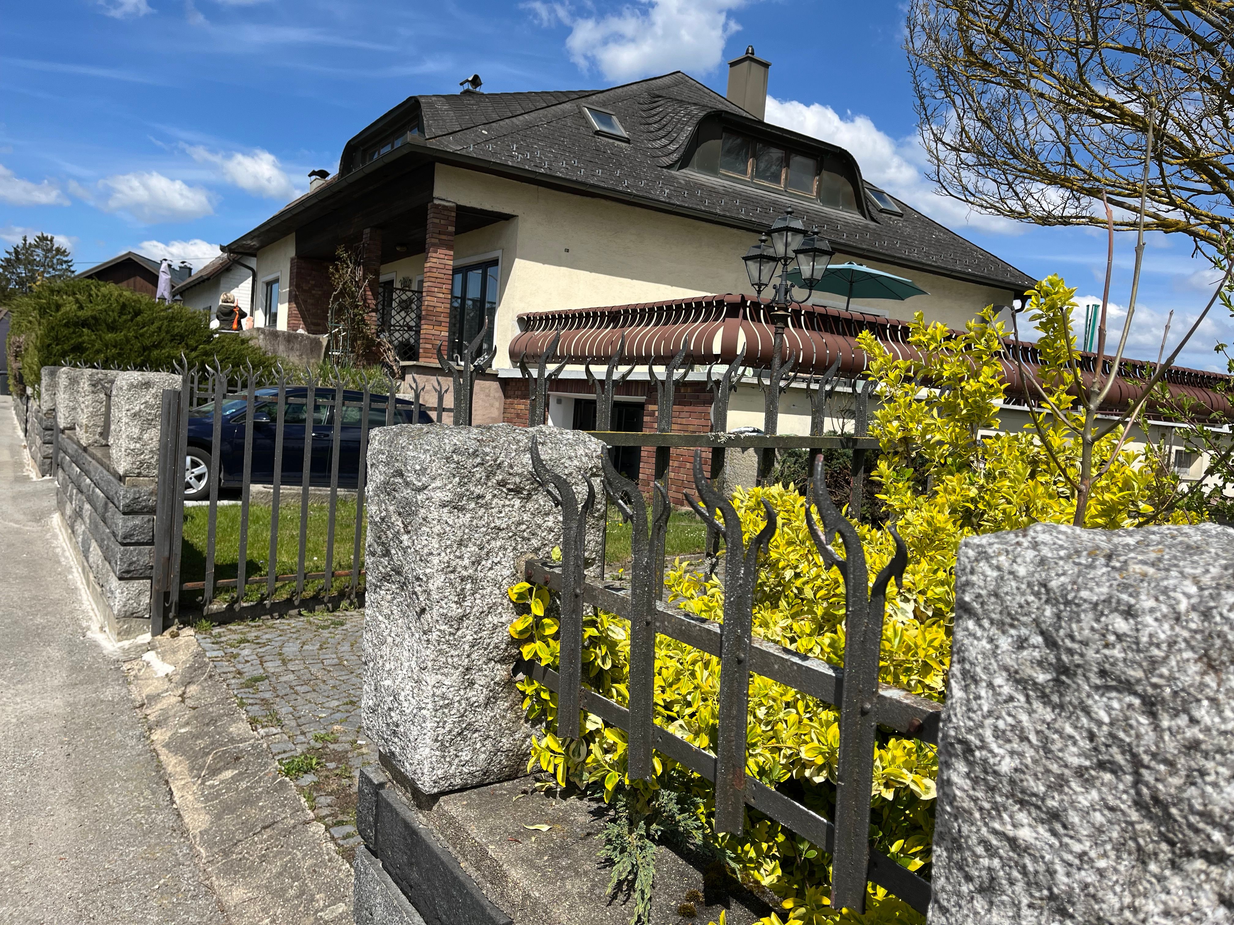 Außenansicht eines Hauses mit Garten und Zaun.