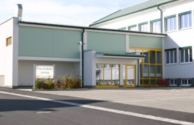 Außenansicht des Hallenbads Dobersberg mit gelben Türen und Fenstern.