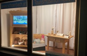 Schaufenster mit Tourismusinformationen und handgefertigten Produkten.