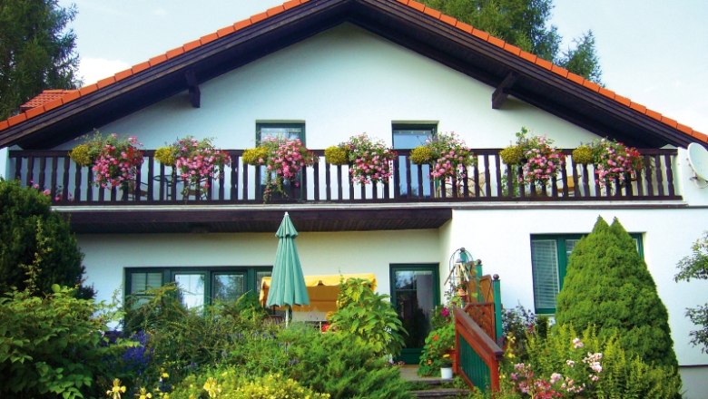 A two-story house with a balcony and flowers.