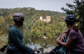 Die sanften H&uuml;gel des Kamptals umarmen die malerische Ruine Dobra, die majest&auml;tisch &uuml;ber dem glitzernden Wasser thront. Radfahrer genie&szlig;en hier eine wohlverdiente Pause, w&auml;hrend sie den atemberaubenden Blick auf die umgebende Natur und die historische Architektur bewundern. Ein Ort, der zum Verweilen und Tr&auml;umen einl&auml;dt.