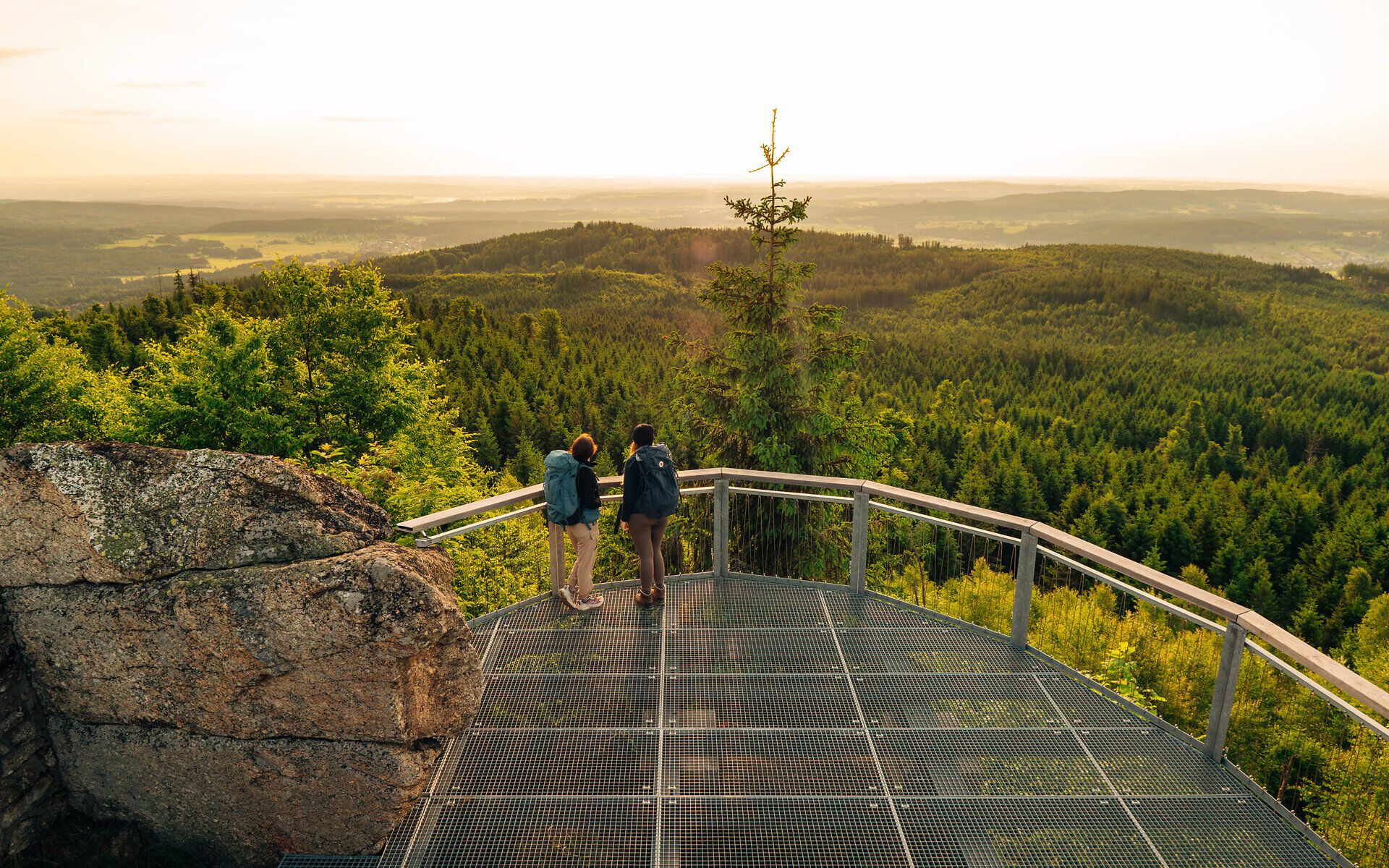 Zwei Frauen stehen auf der Aussichtsplattform am Nebelstein und genießen den weiten Ausblick über die Waldlandschaft