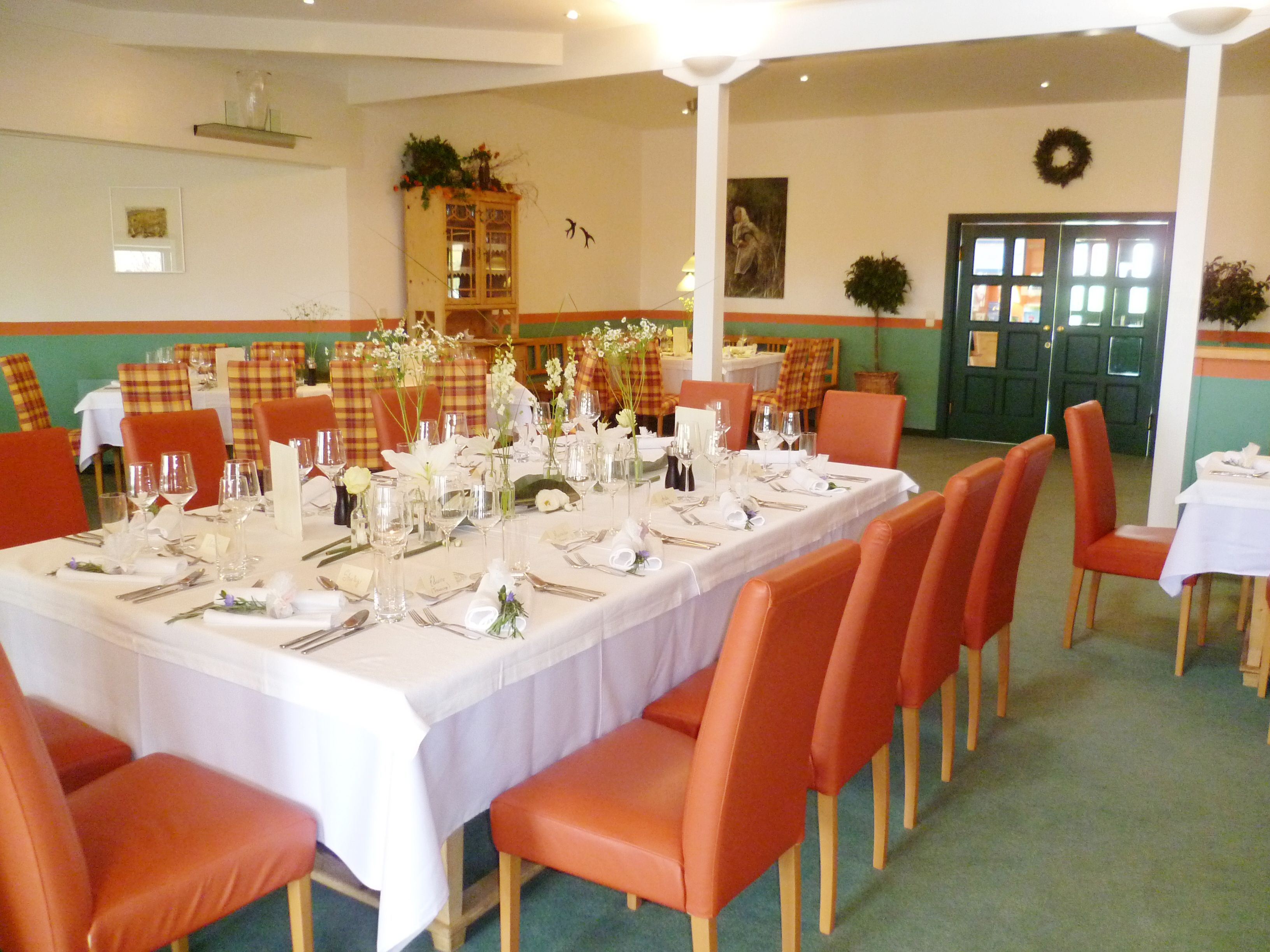 Elegantes Restaurant mit gedecktem Tisch und roten Stühlen.