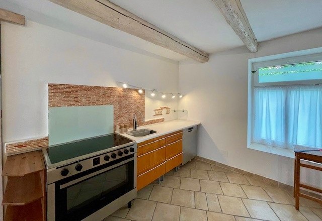 Moderne Küche mit Herd, Holzschränken und Fliesenboden.