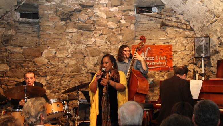 Jazzband spielt in einem rustikalen Club mit Steinwänden.