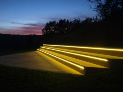 Beleuchtete Treppenstufen im Freien bei Sonnenuntergang.