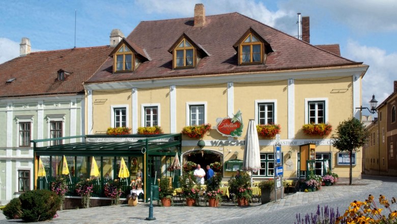 Ein traditionelles Gasthaus mit gelber Fassade und Blumendekorationen.