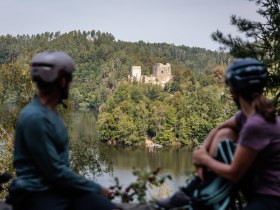 Die sanften H&uuml;gel des Kamptals umarmen die malerische Ruine Dobra, die majest&auml;tisch &uuml;ber dem glitzernden Wasser thront. Radfahrer genie&szlig;en hier eine wohlverdiente Pause, w&auml;hrend sie den atemberaubenden Blick auf die umgebende Natur und die historische Architektur bewundern. Ein Ort, der zum Verweilen und Tr&auml;umen einl&auml;dt.