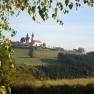 Landschaft mit Kirche Maria Taferl auf einem Hügel, umgeben von Bäumen und Wiesen.