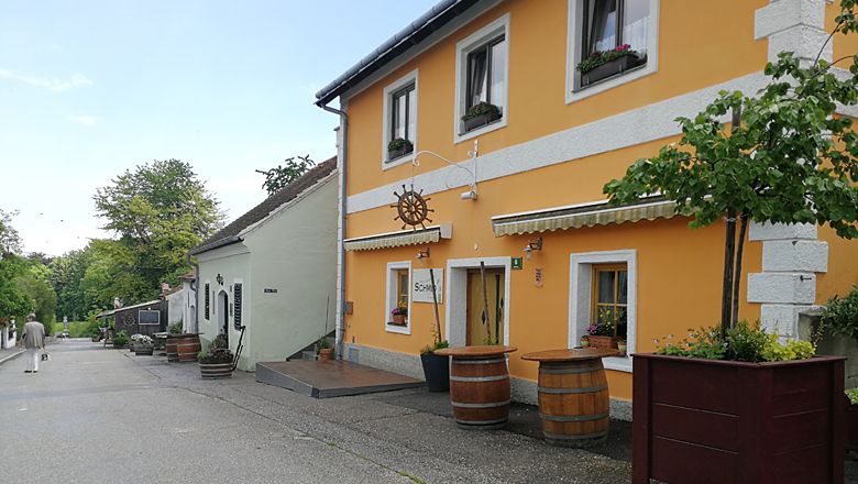 Eine malerische Straße mit traditionellen Häusern und Weinfässern in Langenlois.