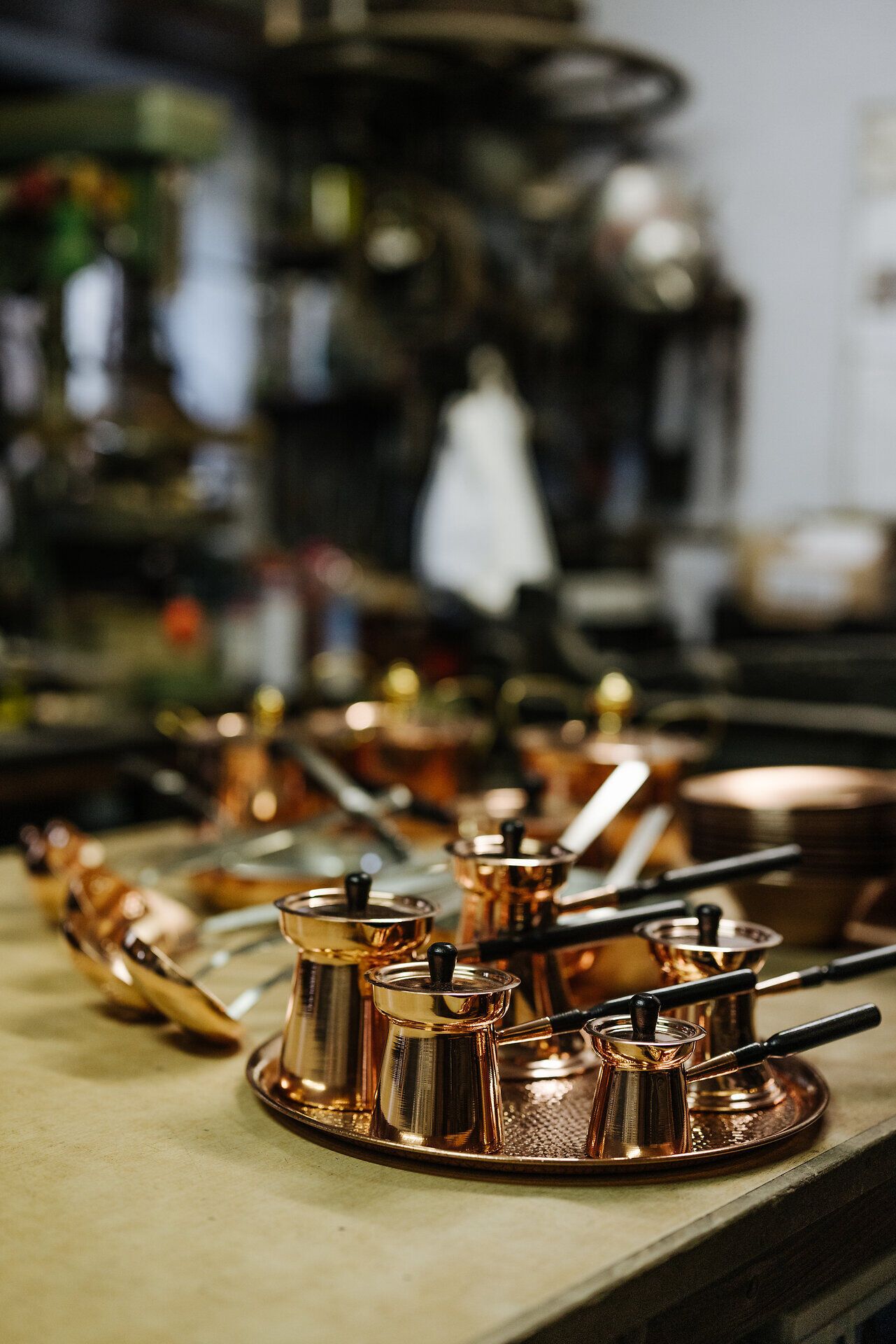 In einer Werkstatt, wo Handwerk und Tradition aufeinandertreffen, glänzen die kunstvoll gefertigten Kaffeekannen aus Kupfer. Die warmen Farbtöne des Metalls strahlen eine einladende Atmosphäre aus, die die Besucher in die Welt des feinen Handwerks entführt.