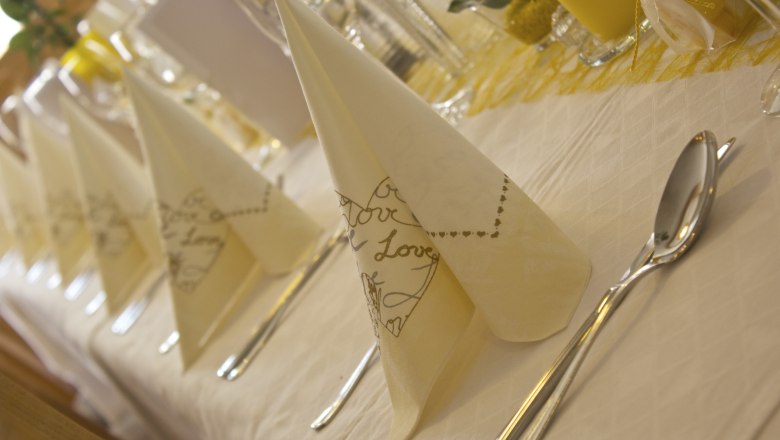 Elegant gedeckter Tisch mit gefalteten Servietten und Besteck.