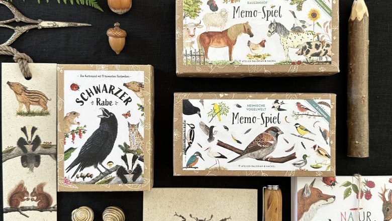 Verschiedene Naturprodukte und Spiele von Atelier Baldiran & Hackel auf einem Tisch arrangiert.