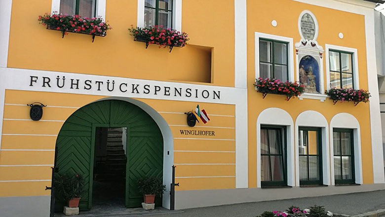 Gästehaus Winglhofer in Gars am Kamp, © Roman Zöchlinger Gelbes Gästehaus mit grüner Tür und Blumenkästen.