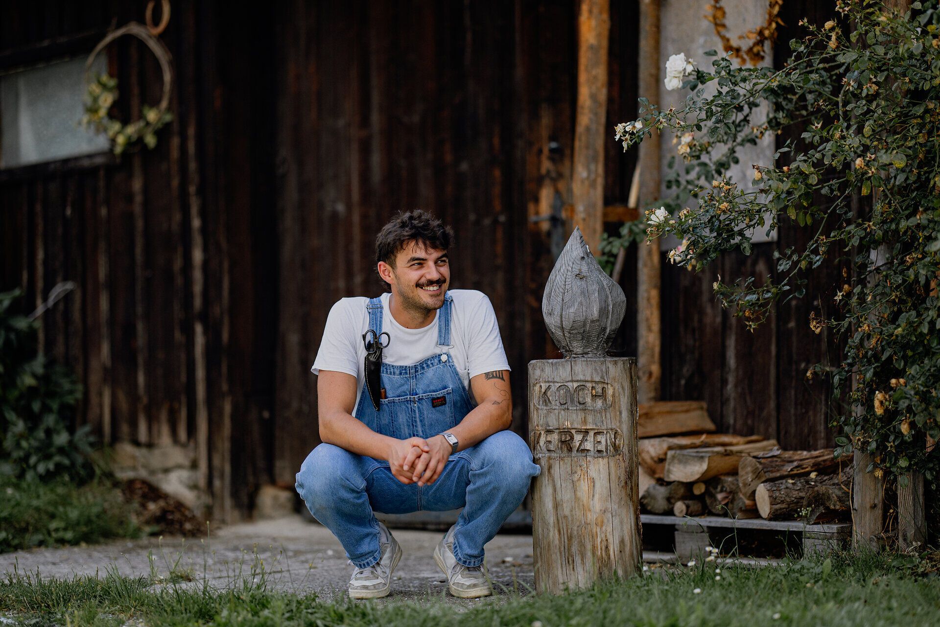 Inmitten der malerischen Kulisse des Waldviertels strahlt die kreative Atmosphäre eines Handwerkskurses. Ein junger Mann, umgeben von duftenden Pflanzen und rustikalen Holzelementen, genießt die Kunst des Kerzenmachens und lässt seiner Kreativität freien Lauf.