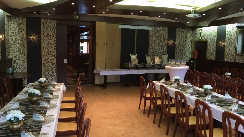 Eleganter Speisesaal mit gedeckten Tischen und Stühlen.