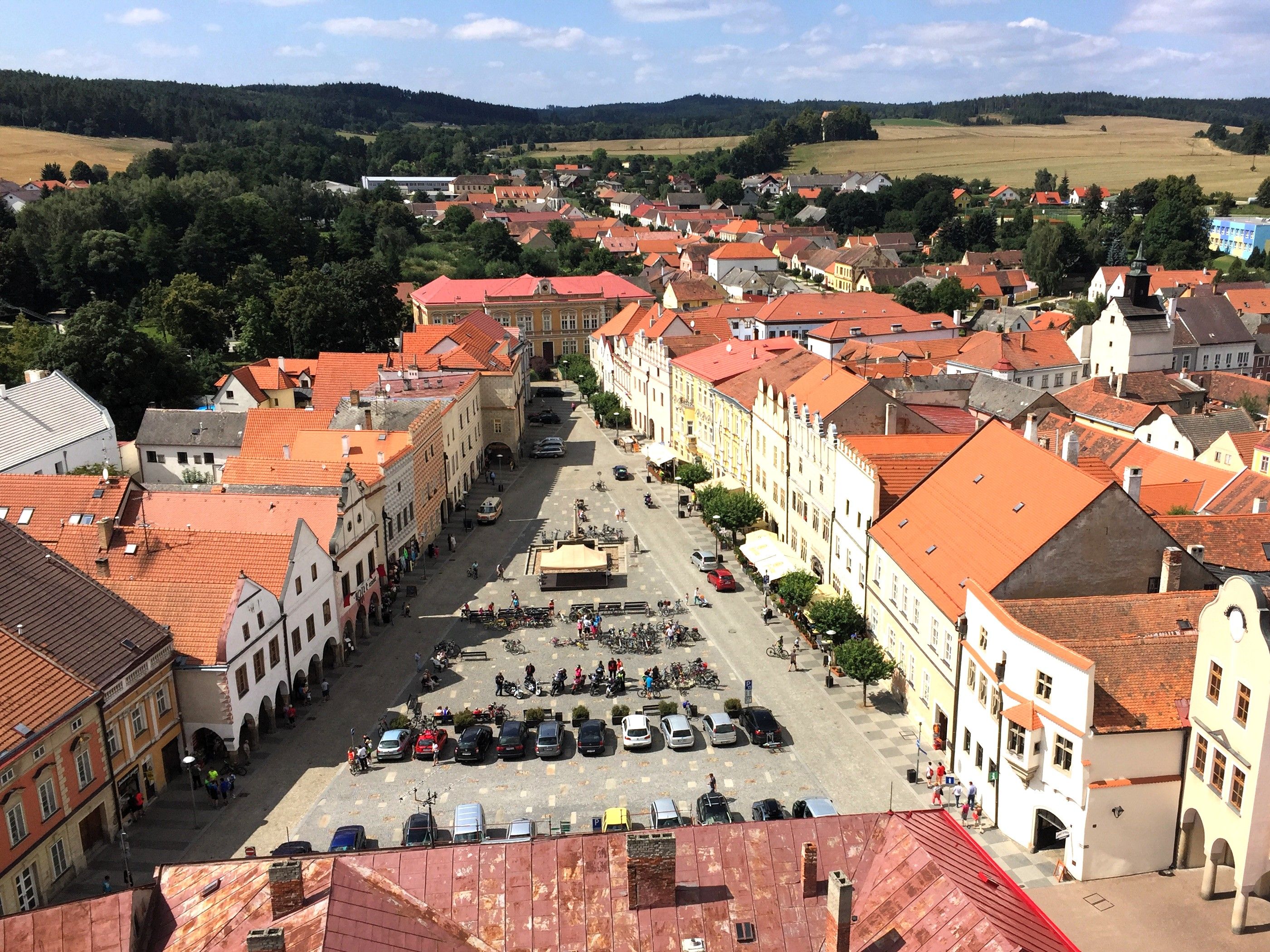 Belebter Stadtplatz umringt von Sgraffitohäusern