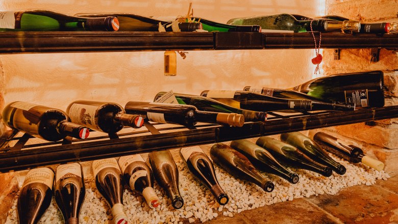 L&aacute;hve v&iacute;na na polici na b&iacute;l&yacute;ch kamenech.