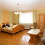 Comfortable hotel room with wooden furniture, bed, sofa and table.
