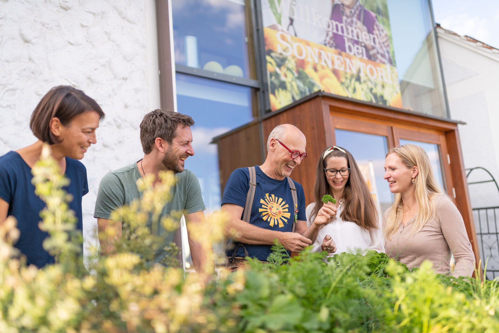 Inmitten der duftenden Kräuter und frischen Pflanzen versammeln sich die Besucher, um mehr über die Kunst der Teezubereitung zu erfahren. Die strahlenden Gesichter und die lebhafte Atmosphäre laden dazu ein, die Natur in ihrer vollen Pracht zu genießen.