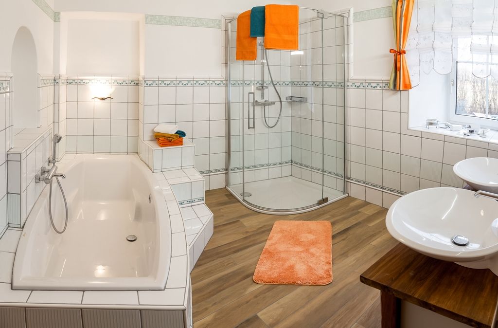 Modernes Badezimmer mit Badewanne, Dusche und Doppelwaschbecken.