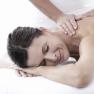 Woman receives a back massage and smiles relaxed.