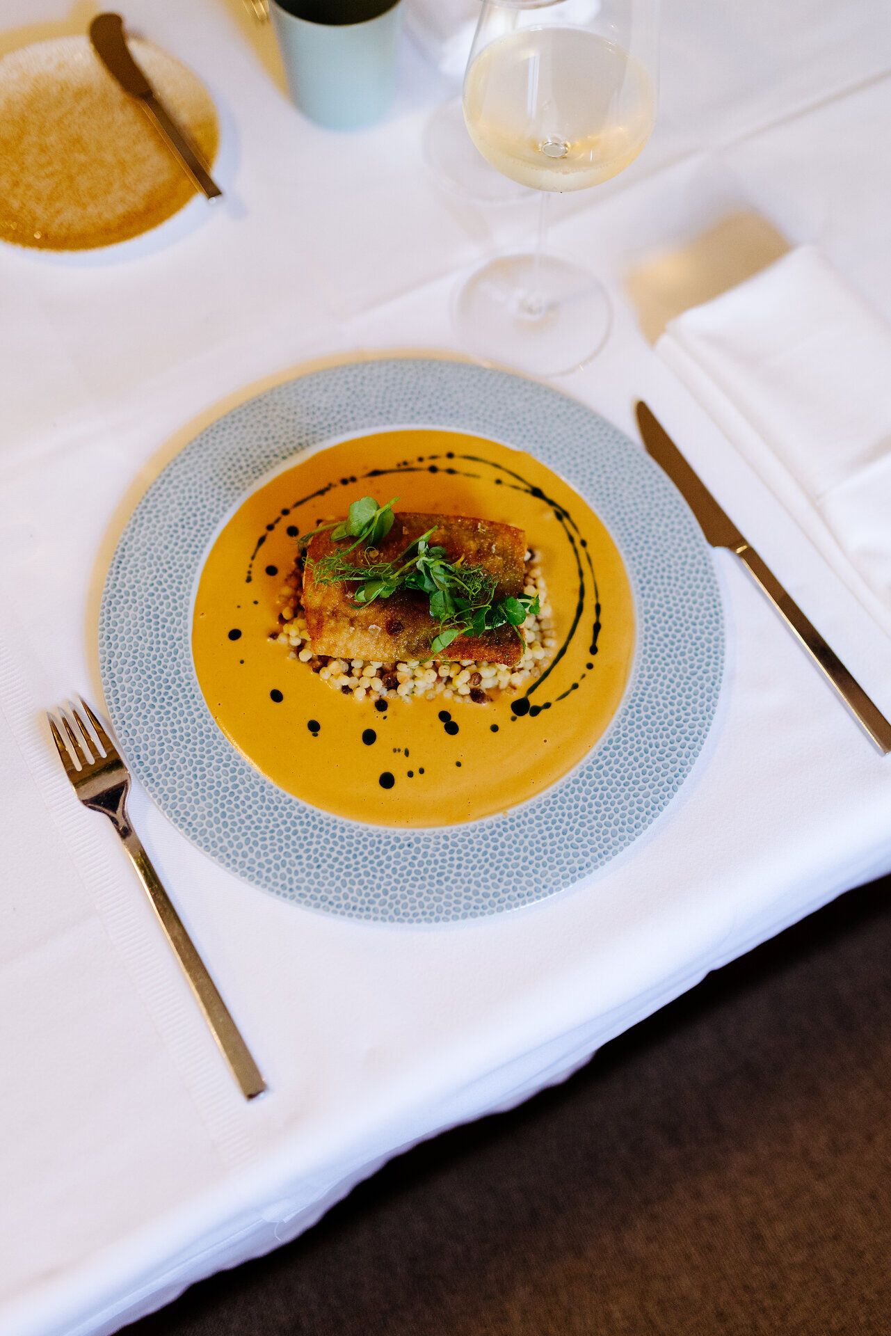 Ein kunstvoll angerichteter Teller mit einer köstlichen Speise, die die Sinne verführt. Die harmonischen Farben und die frischen Kräuter verleihen dem Gericht eine einladende Note, die zum Genießen einlädt. Ein perfekter Moment, um die kulinarischen Köstlichkeiten der Region zu entdecken.