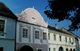Historische Gebäude in Hadersdorf-Kammern mit blauer und rosa Fassade.