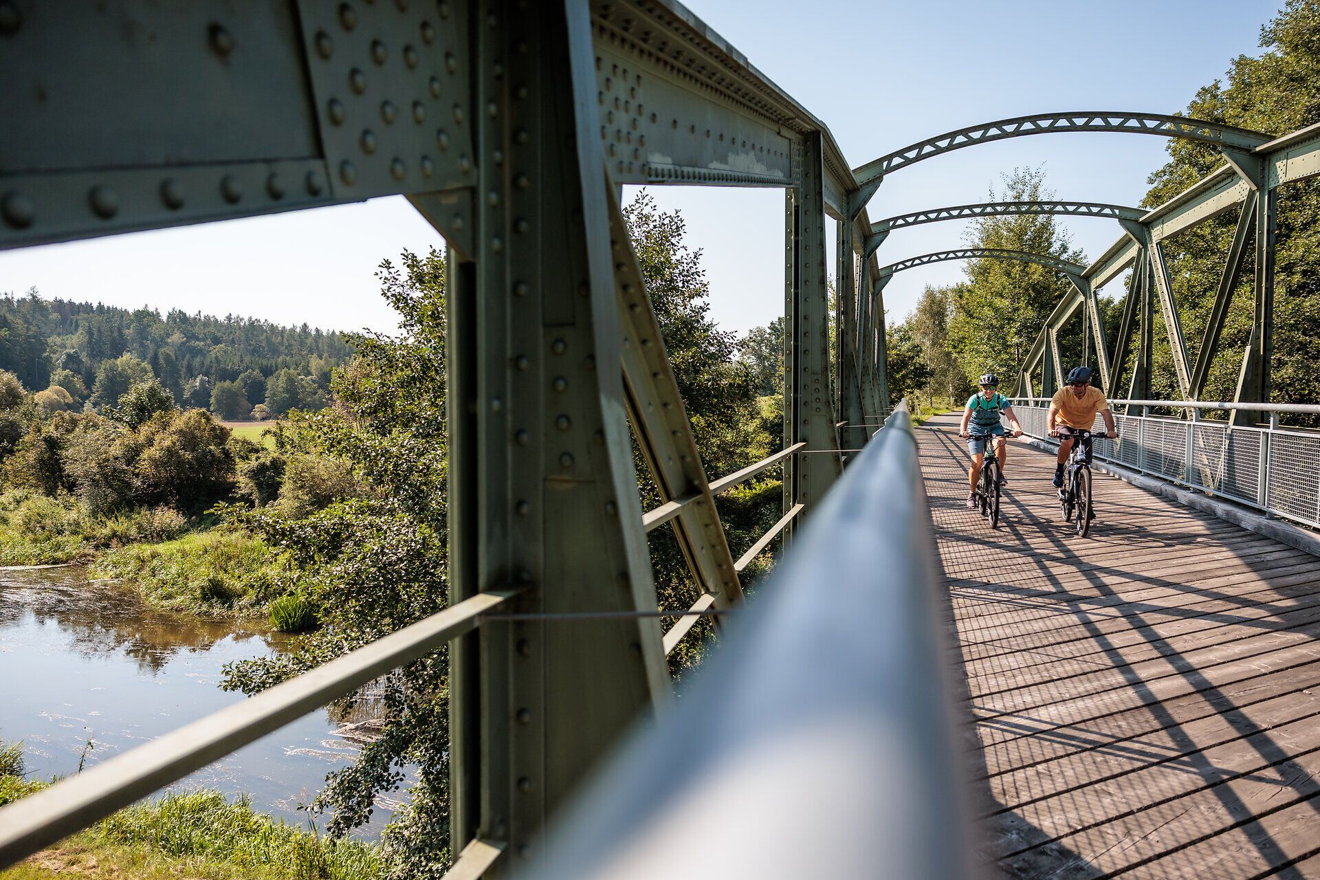 Die sanfte Brise weht über die Thayabrücke, während Radfahrer die malerische Landschaft genießen. Umgeben von üppigem Grün und dem sanften Plätschern des Wassers, lädt dieser Ort dazu ein, die Schönheit der Natur zu erleben und die Seele baumeln zu lassen.