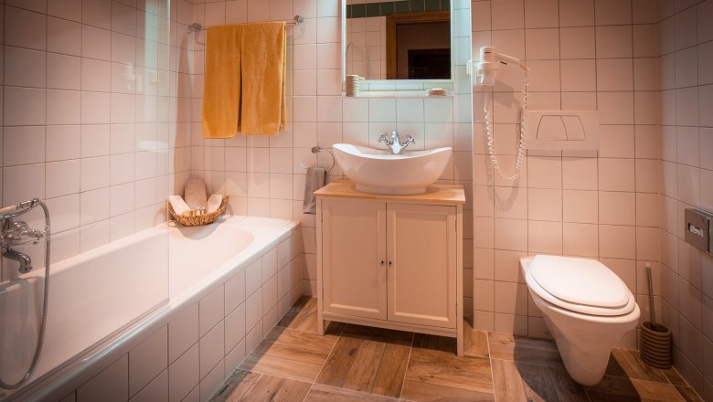 Modernes Badezimmer mit Badewanne, Waschbecken und Toilette.