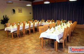 Ein festlich gedeckter Tisch in einem Restaurant mit Holzstühlen und weißen Tischdecken.